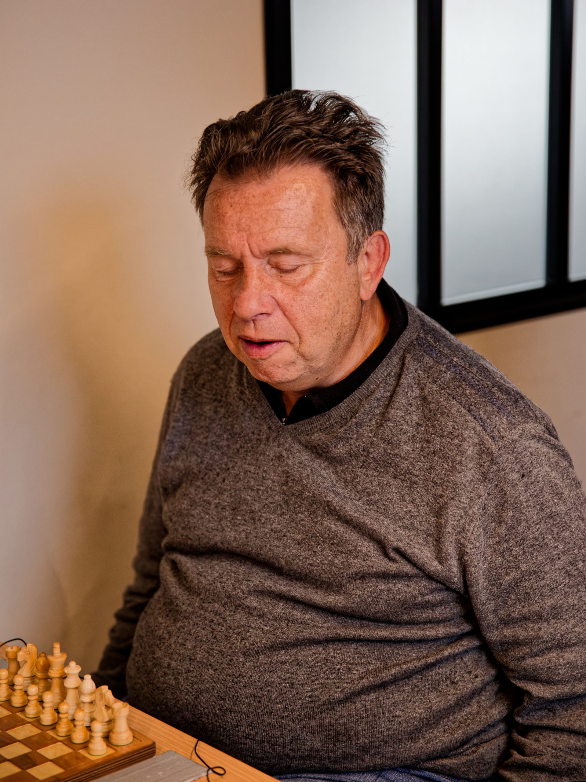 Alain VALMALETTE semble vouloir rapprocher sa chaise pour s'approcher de son échiquier et en découdre.