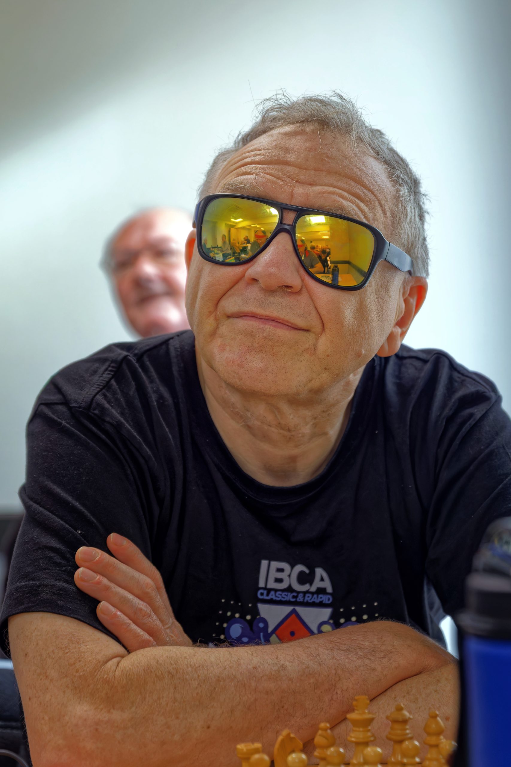 Olivier DEVILLE attendant les bras croisés le début de la ronde. Le visage de Mickaël, reconnaissable à son bandeau rouge, se reflètent dans ses lunettes.