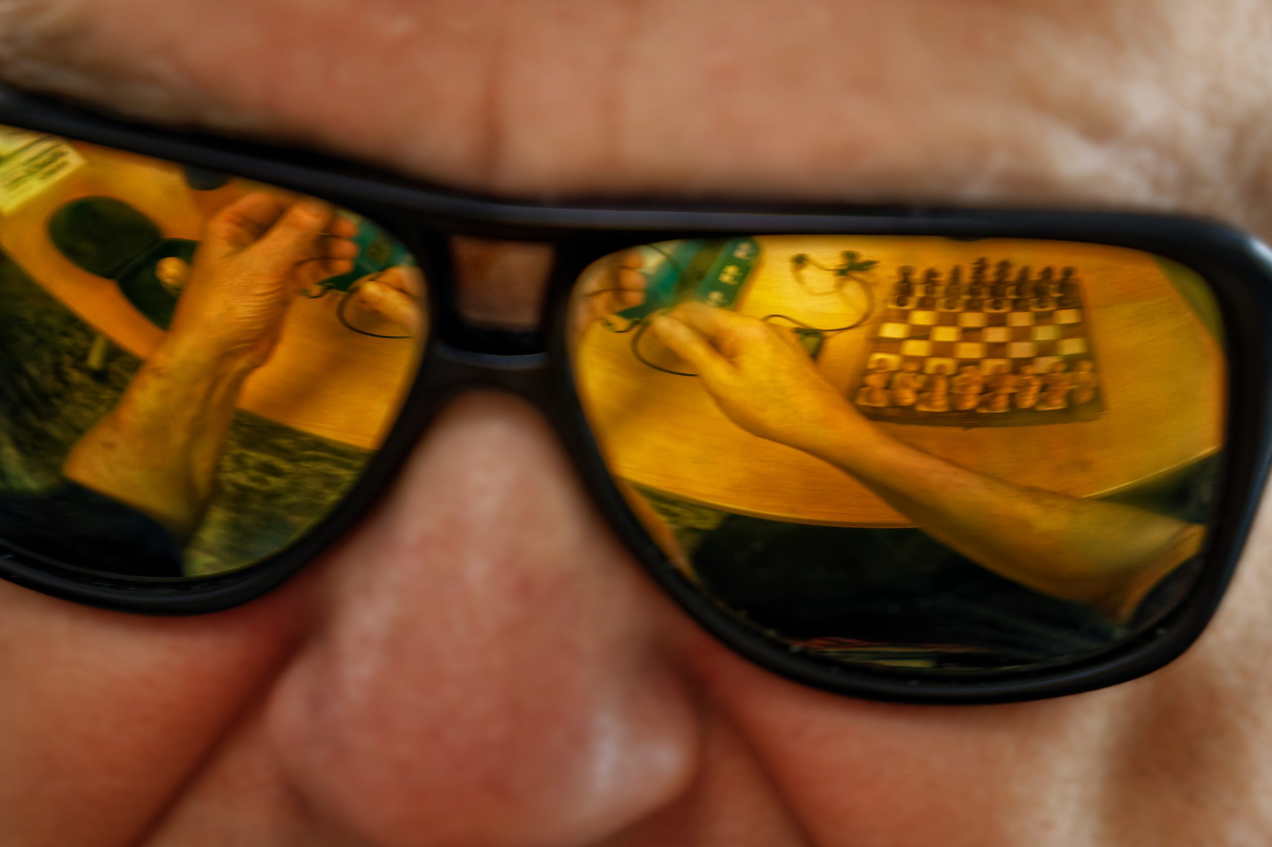 Plongée dans les lunettes d'Olivier, on voit ses mains démêler le fil de son écouteur.