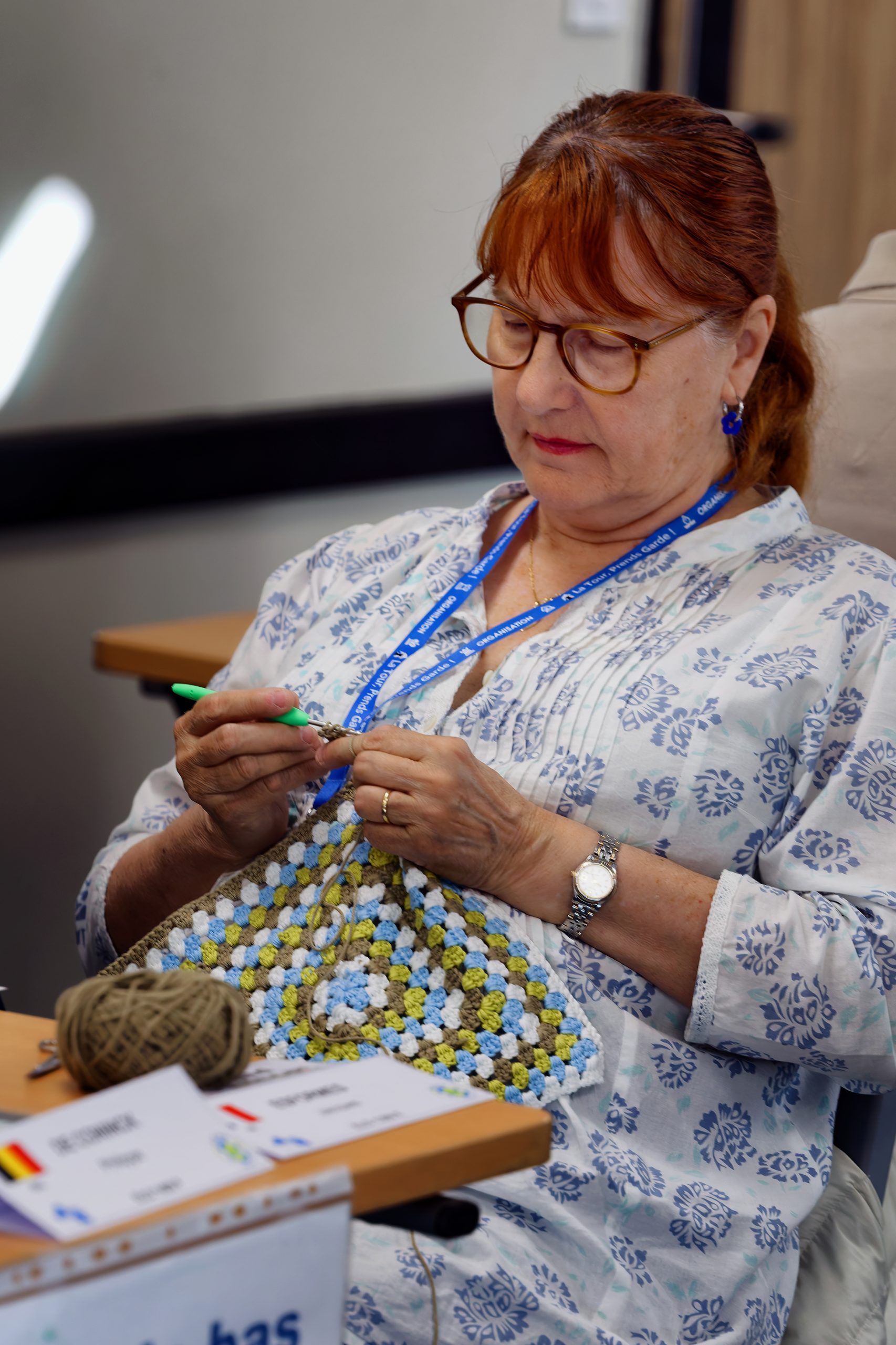 Marie-Paule s'occupe de son tricot à côté de Jacques ESFORMES qui joue à côté.